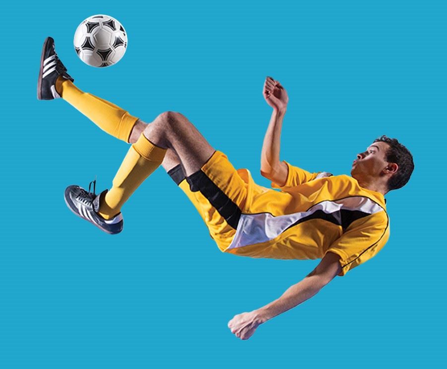 Soccer player airborne while kicking ball